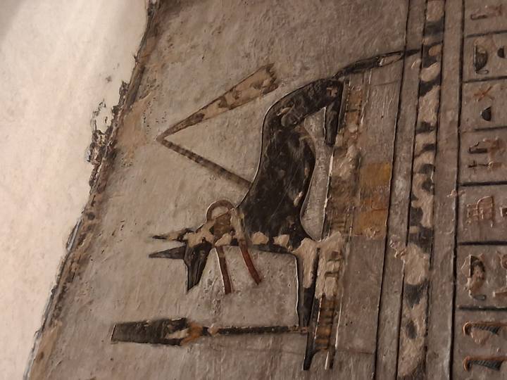 Ancient mural of a deity on a stone wall.