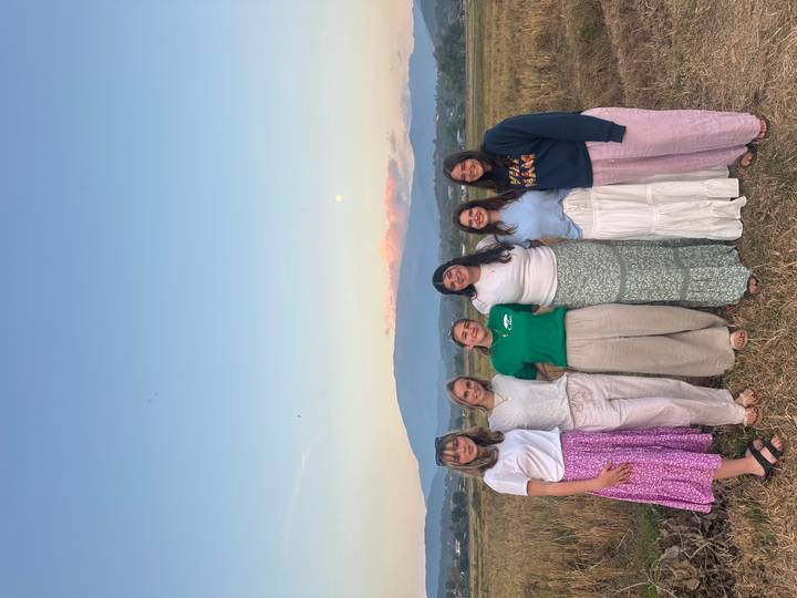 Groupe de personnes posant ensemble à l'extérieur avec vue sur la montagne.