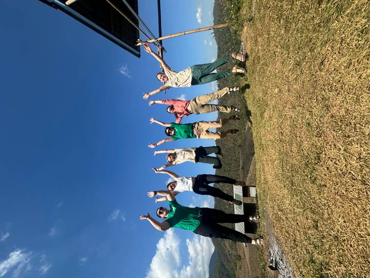Groupe de personnes sautant en l'air avec des montagnes en arrière-plan.