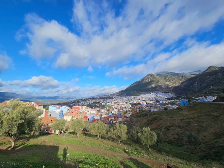View of Chefchaouen with colorful buildings against a mountain backdrop.