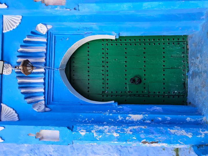 Green door set in a blue wall, typical of Chefchaouen.