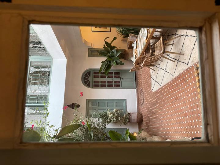 Cour avec un aménagement de salle à manger, des plantes en pot et une architecture traditionnelle.