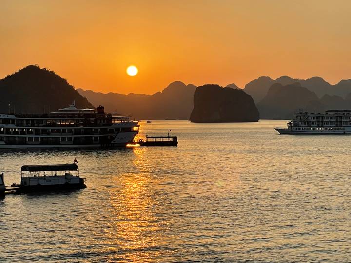 Coucher de soleil sur l'eau avec des navires de croisière.