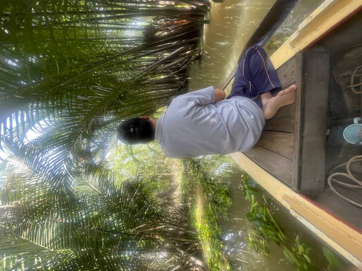 Personne assise dans un bateau naviguant dans des eaux tropicales.