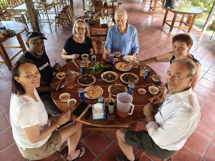 Des touristes savourant un repas ensemble à une table garnie de plats traditionnels.