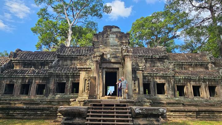 Deux personnes posant devant les ruines d'un temple ancien.