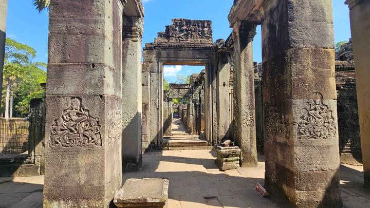 Ruines de temple en pierre avec sculptures et colonnes.
