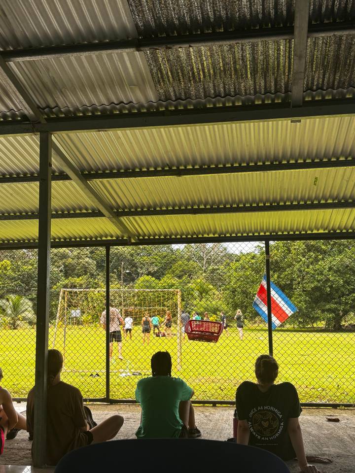 Campo deportivo con una bandera costarricense colgando en la cerca.