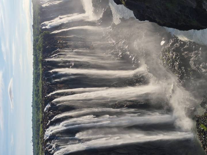 Tres individuos con vestimenta roja tradicional, al aire libre.