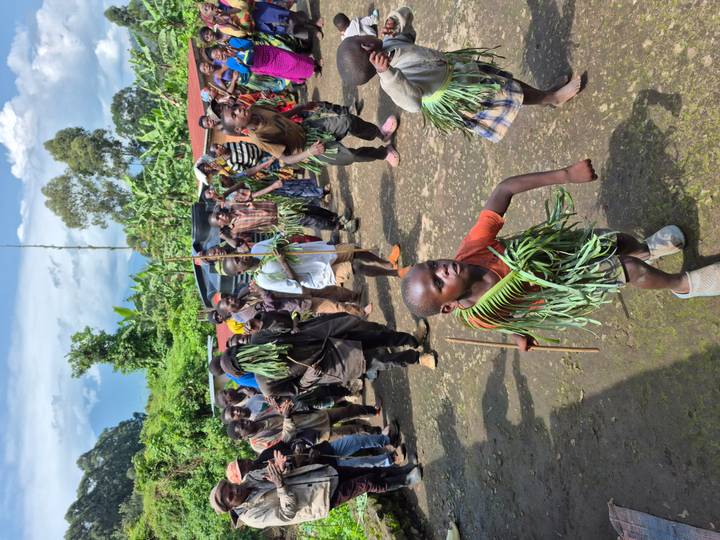 Niños en traje tradicional participando en una danza cultural.