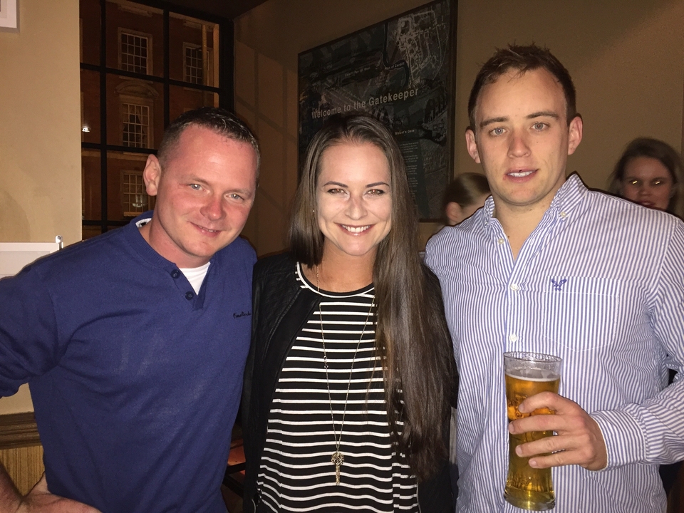 Trois personnes souriant à l'intérieur.