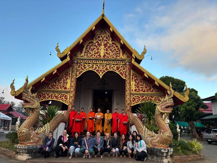 Groupe de moines et de touristes devant un temple.