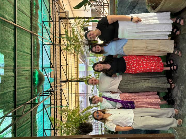 Groupe de personnes posant devant de la verdure.