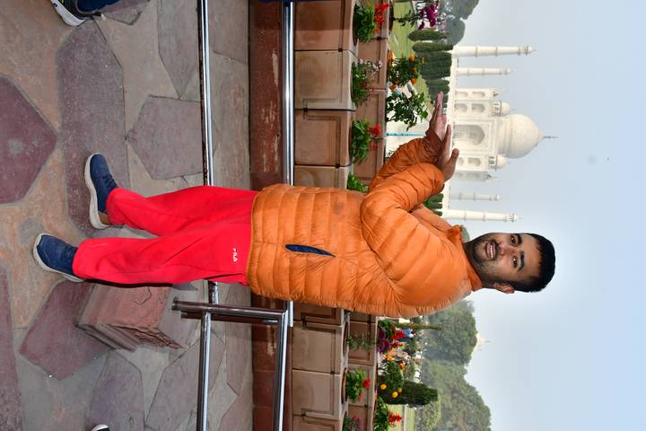 Person posing in front of the Taj Mahal.