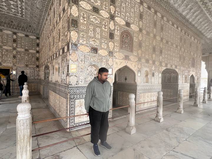 Person inside an ornate marble building with intricate carvings.