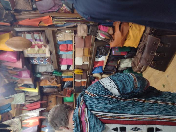 Magasin avec divers sacs colorés exposés.