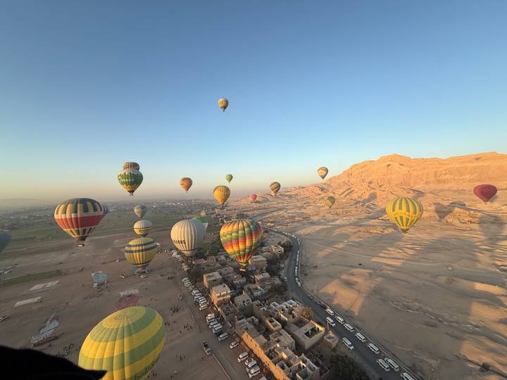 Globos aerostáticos flotando sobre el vasto paisaje desértico.