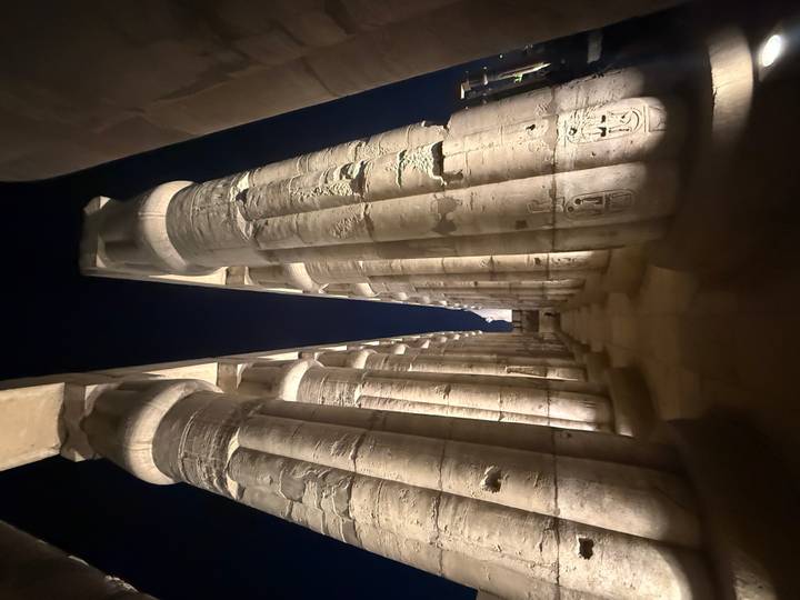 Columnas antiguas iluminadas por la noche en un lugar histórico.