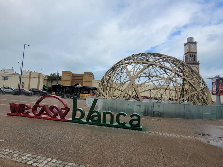 Structure architecturale avec panneau Casablanca et des personnes autour.