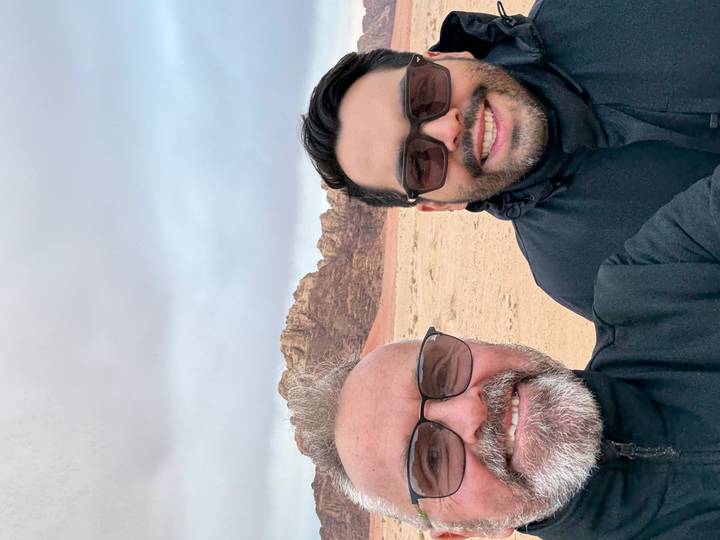 Deux hommes prenant un selfie dans une zone désertique.