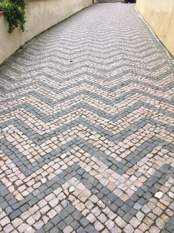 Une chaussée pavée à motifs en forme de chevrons.