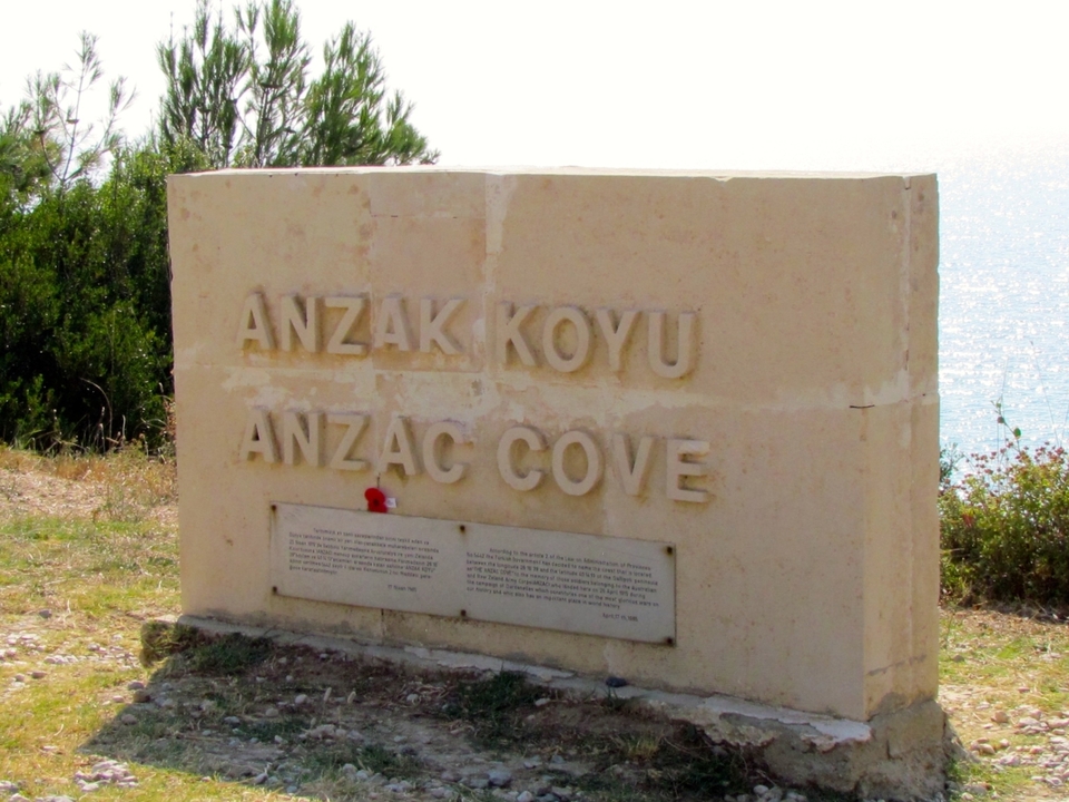 Mémorial en pierre avec texte gravé près d'un littoral.