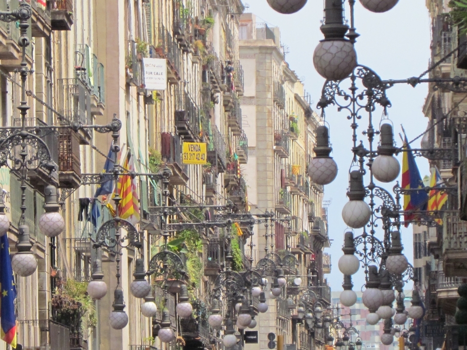 Vue de la rue avec des lampadaires décoratifs et des drapeaux.