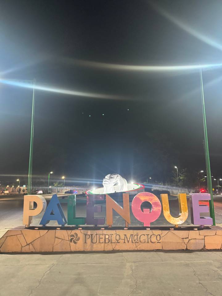 Sculpture of a face with colorful lights at night.