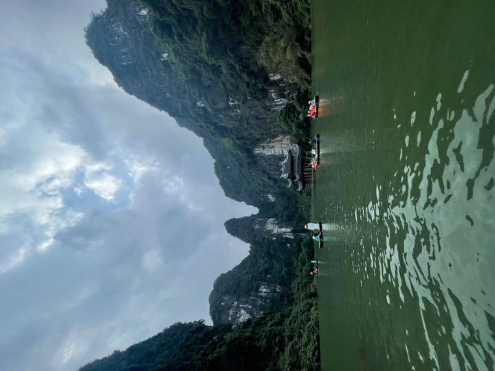 Kajakfahrer paddeln durch einen Fluss in einer bergigen Gegend.