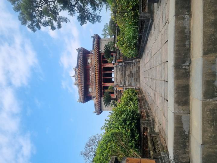 Edificio de templo antiguo en un entorno de jardín exuberante.