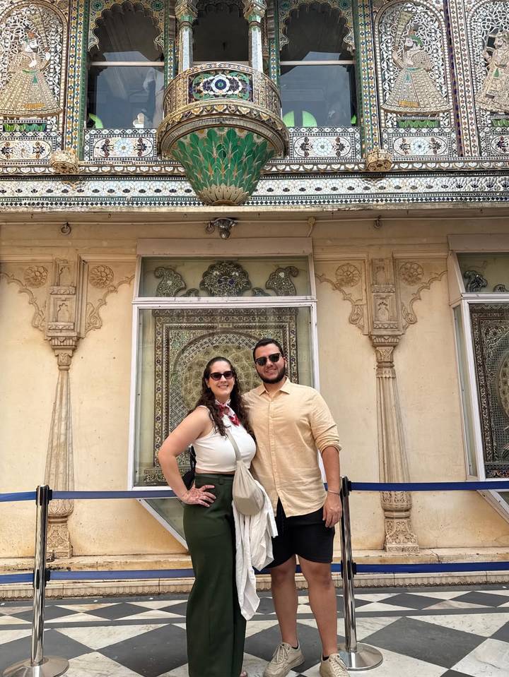 Una pareja de pie frente a un edificio histórico con diseños intrincados.