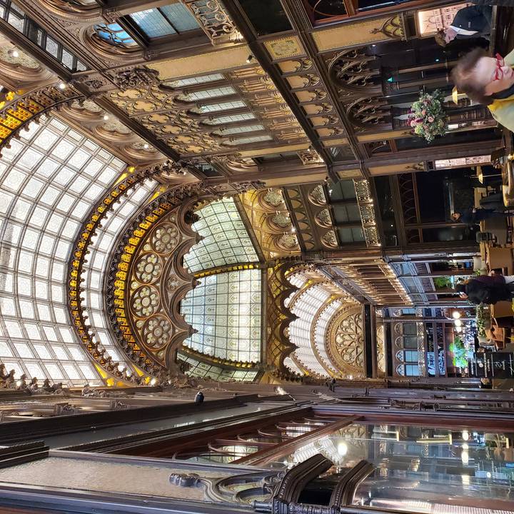 Atrium intérieur architecturalement complexe avec des personnes qui marchent.