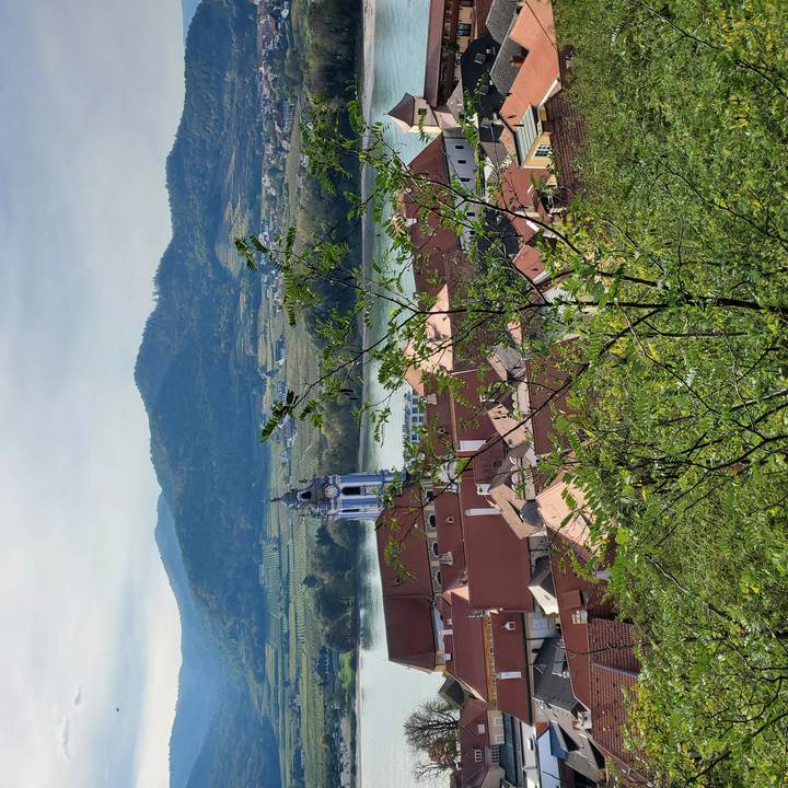 Vue pittoresque d'une ville avec rivière et clocher d'église.