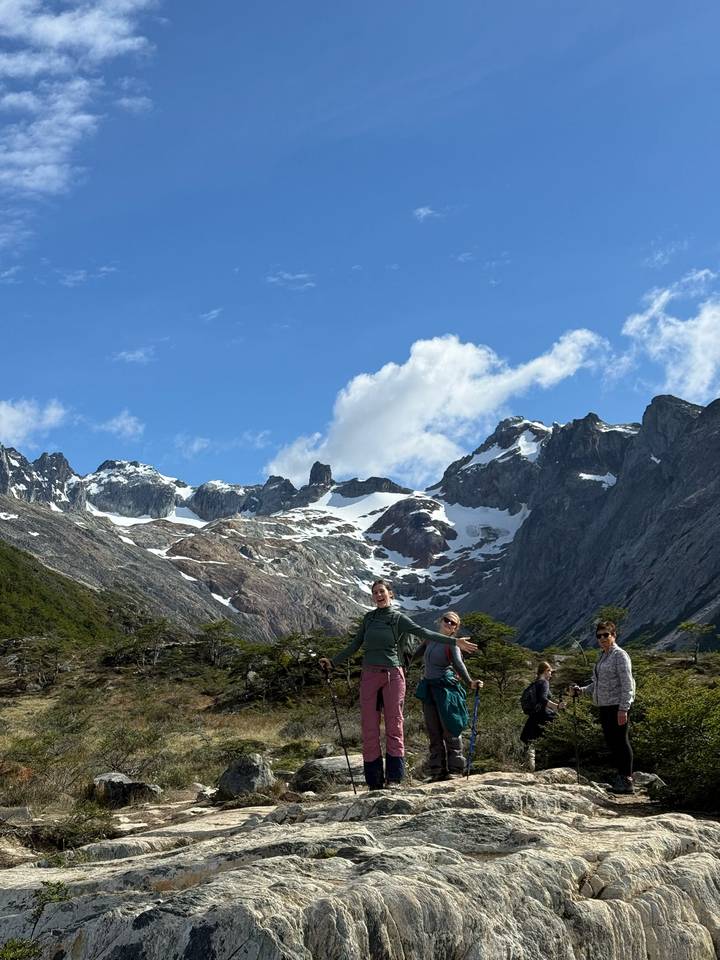 Trois personnes posant devant des montagnes enneigées.