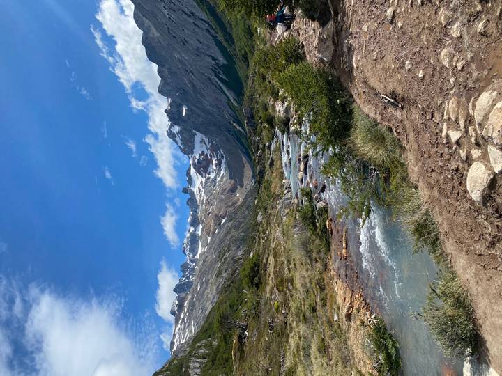Une rivière coulant à travers un paysage montagneux avec des sommets enneigés.