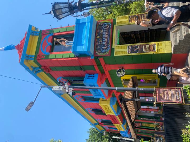 Bâtiment coloré à Caminito avec des gens qui se promènent dans la rue.