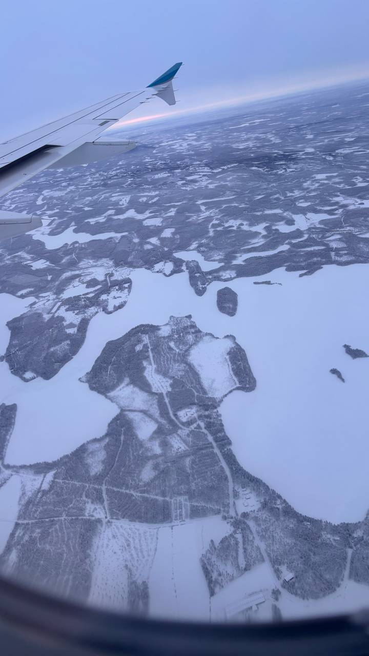 Vista aérea de un paisaje nevado con lagos congelados y bosques.