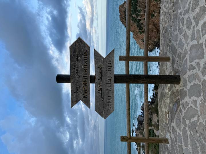 Poste indicador con direcciones hacia los océanos Mediterráneo y Atlántico junto a la costa.