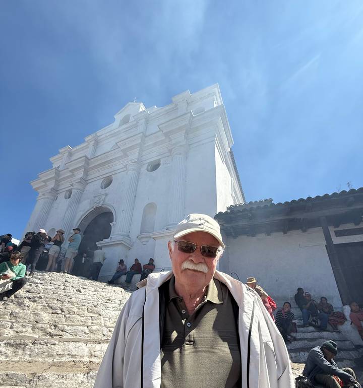 Groupe de touristes sur un site historique, avec une cathédrale blanche.