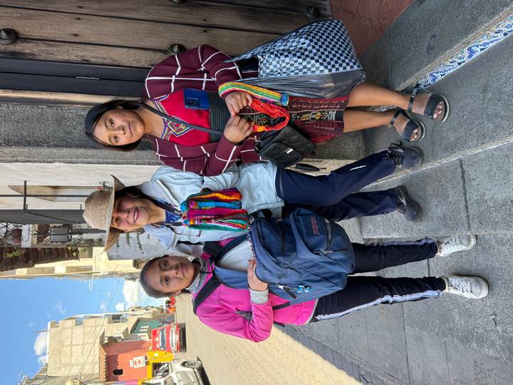 Femme posant avec deux jeunes filles en tenue traditionnelle.