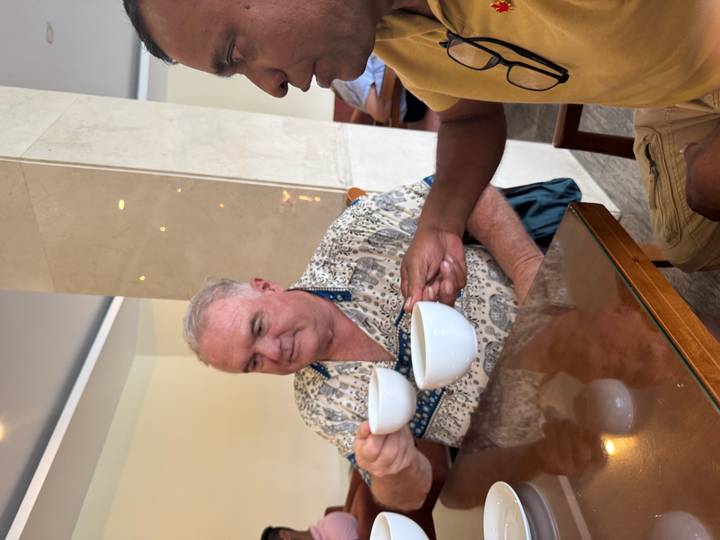 Two men having a drink, sitting inside a casual setting.