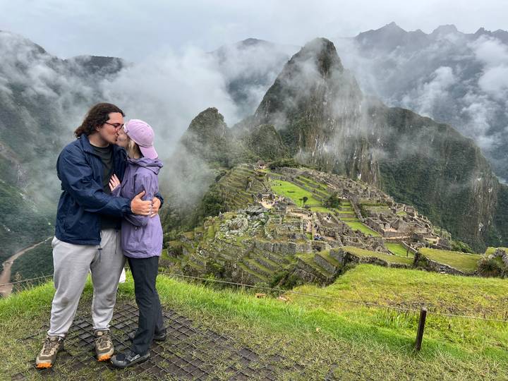 Paar küsst sich mit Blick auf Machu Picchu im Hintergrund.