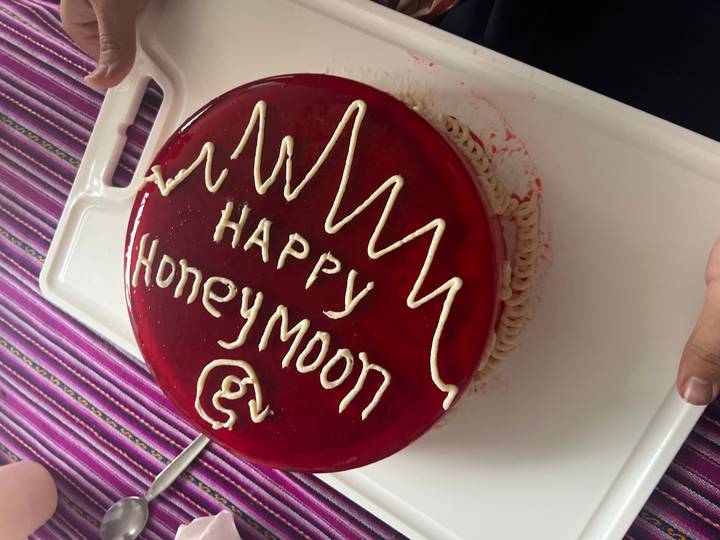 Nahaufnahme eines Kuchens mit der Aufschrift 'Happy Honeymoon'.