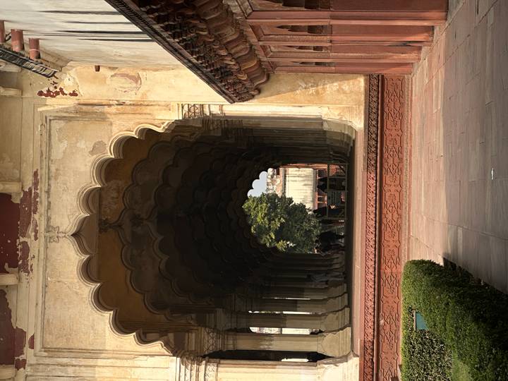 Mughal arched colonnade with deep shadows leading to a courtyard inside Agra Fort.
