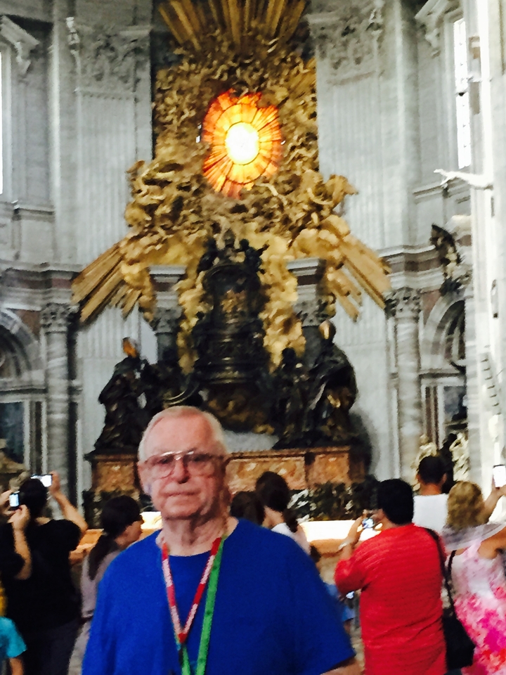 Homme debout à l'intérieur d'une église aux décorations ornementales.
