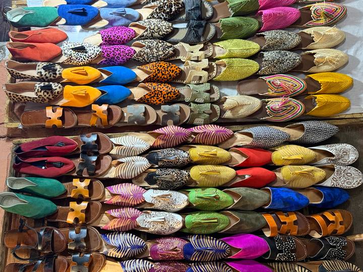 Colourful array of traditional leather slippers neatly displayed in a souk stall.