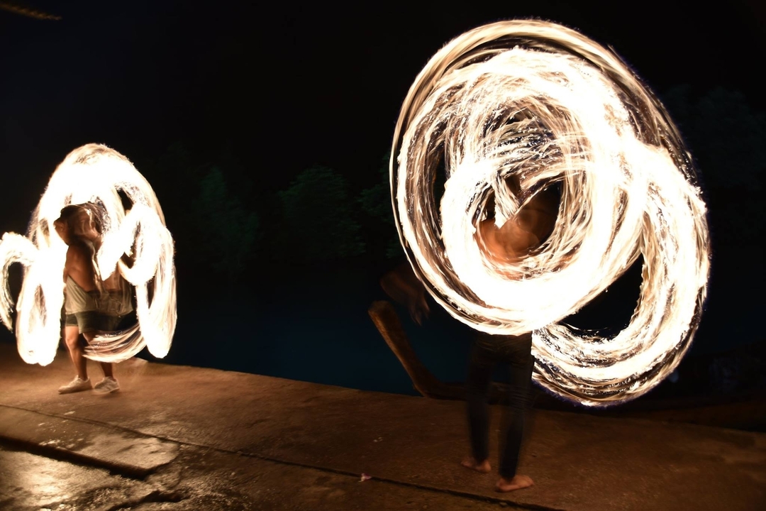 Deux personnes effectuant des filatures de feu la nuit.