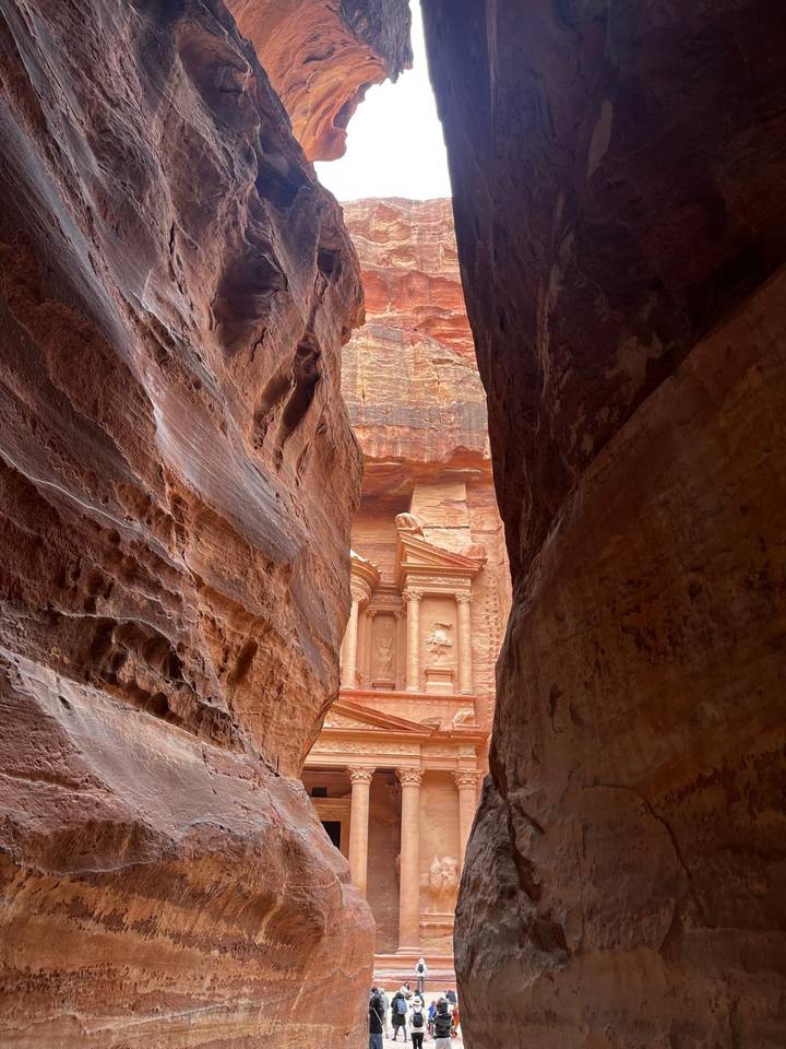 The Treasury of Petra dramatically revealed through the narrow sandstone walls of the Siq.
