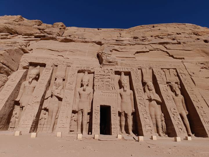 Sandstone façade of Abu Simbel’s smaller temple with row of standing deities.