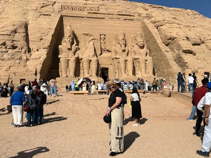 Crowds exploring the colossal statues of Abu Simbel temple in bright sunlight